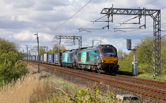 68002 & 88007 head away from Hest Bank with 4S43 Daventry to Mossend on 27.4.24.