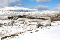 66743 heads 6M38 11.25 Arcow Quarry to Bredbury past Ribblehead station on 27.2.20.