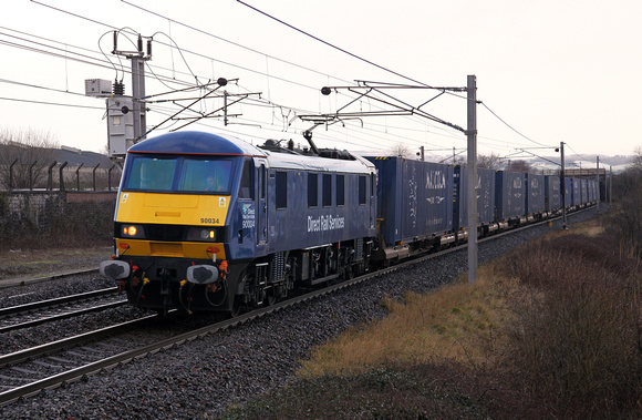 DRS liveried 90034 passes Carnforth with 4M25 Mossend to Daventry on 16.1.15.