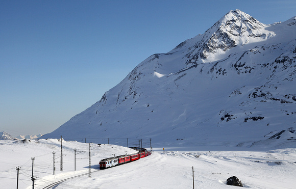 A Tirano to St Moritz train heads away from Ospizio Bernina on the 18.3.15.